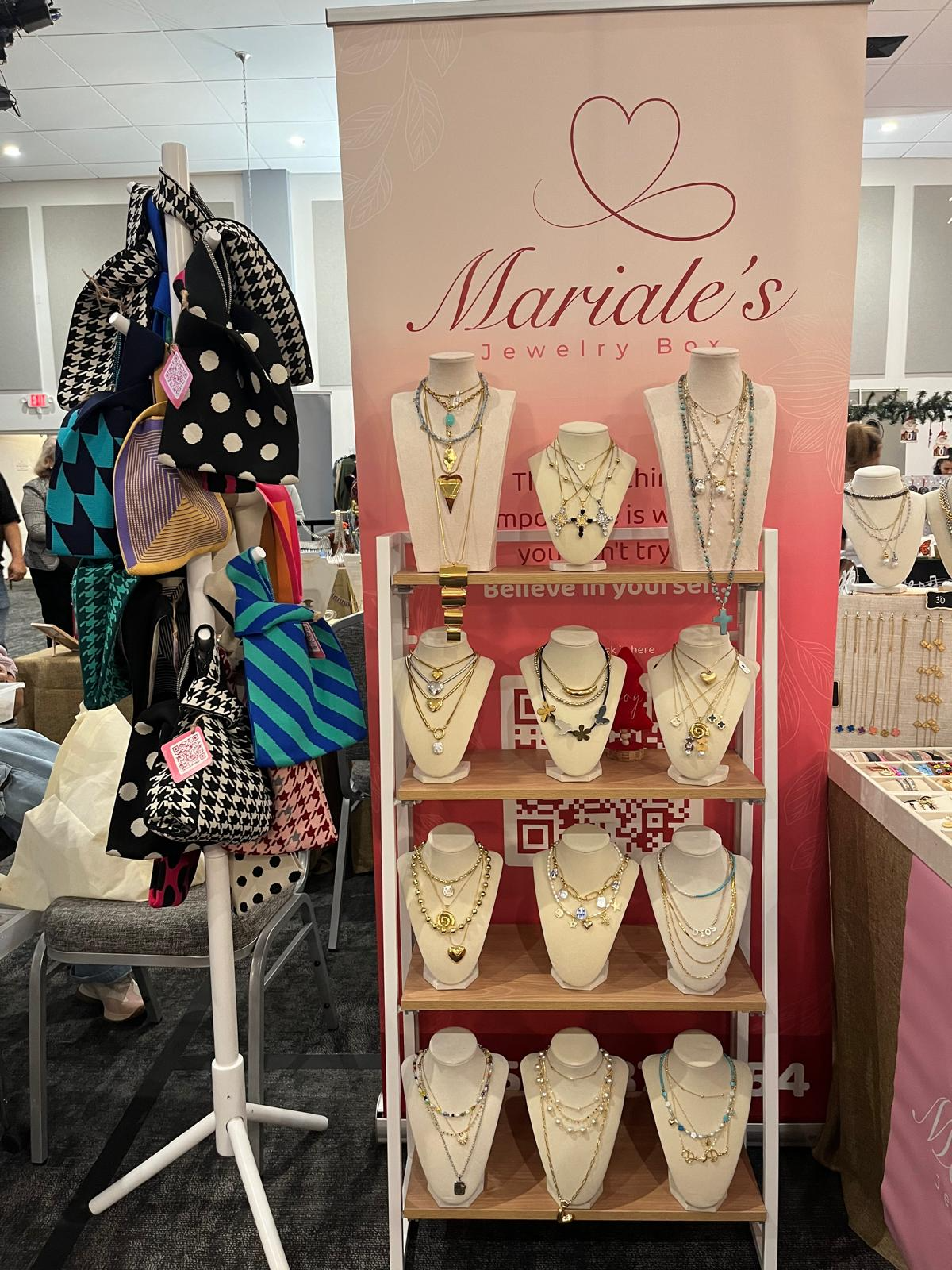 Stand de Mariale's Jewelry Box en un bazar con collares dispuestos en bustos